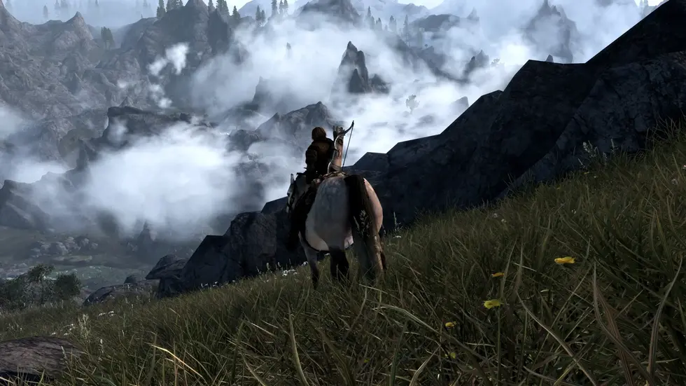 Воин на коне с луком смотрит на горную долину в тумане, Skyrim