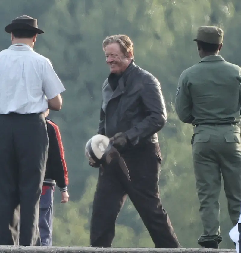 Улыбающийся Брендан Фрейзер в кожаной куртке и со шлемом в руках на съемочной площадке